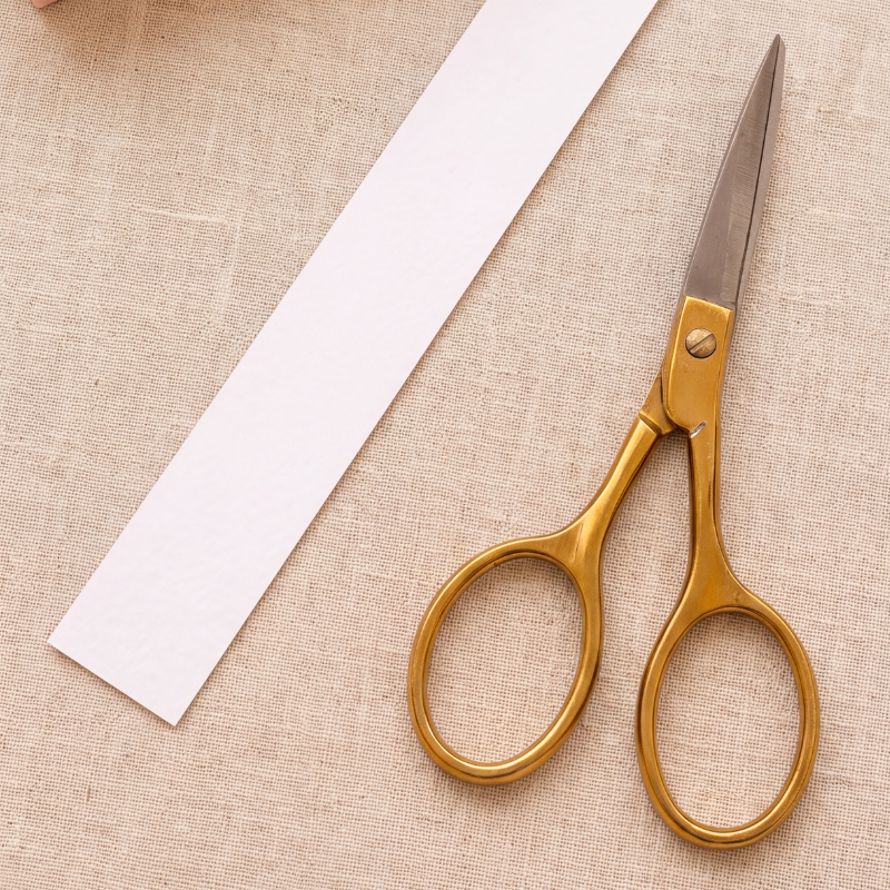 A strip of paper being cut with scissors